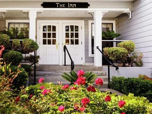 The front door of the Inn at Saratoga behind pink roses