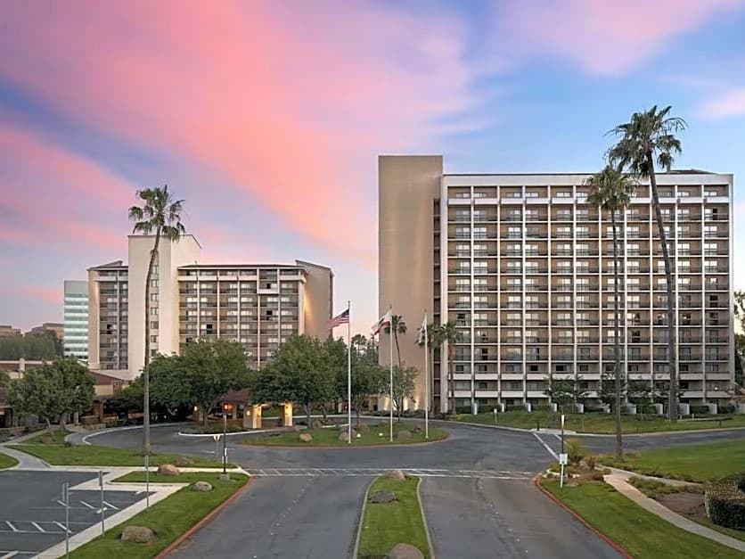 The Santa Clara Marriott's two towers and palms under a pink sunset sky